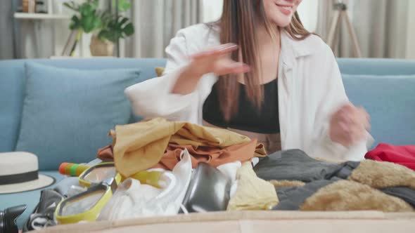 Asian Young Woman Packing Clothes In Suitcase At Home, Preparing For Vacation