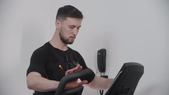 A Man in Ems Suit Working Out in the Gym