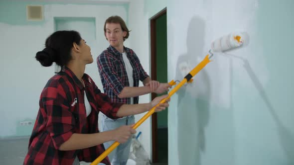 Cheerful Couple Renovating Home with Fresh Paint