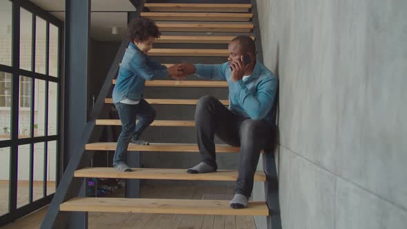 Lovely Little Boy Talking on Cellphone on Stairs