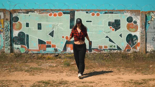 Young Girl Dancing Shuffle Against a Gray Painted Wall