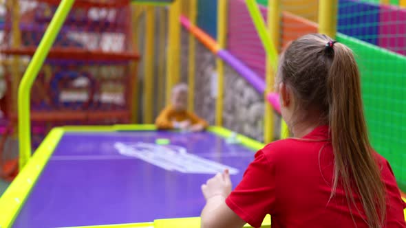 Happy Smiling Little Boy and Girl Play Air Hockey