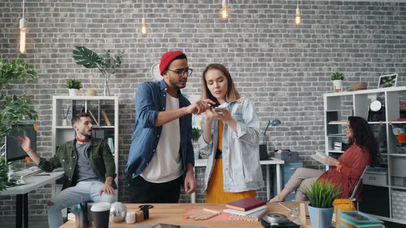 Girl and Guy Designers Shooting Flat Lay on Office Desk Using Smartphone Camera