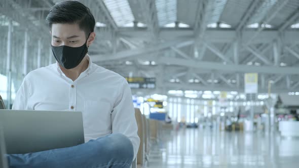 Social distancing, businessman wearing face mask sit working with laptop keeping distance