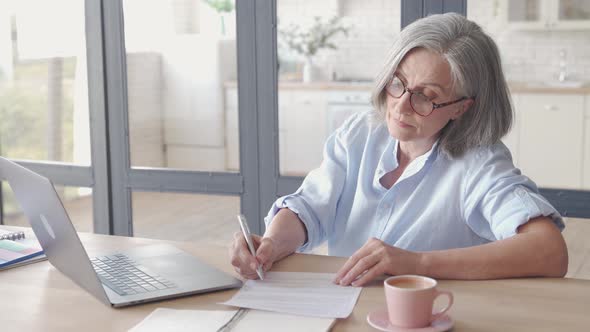 Senior Older Business Woman Video Calling on Laptop From Home Office