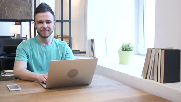 Young Designer  Smiling  toward Camera, Working in Office