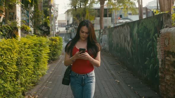 a Beautiful Trans Woman Chatting While Walking Down the Street