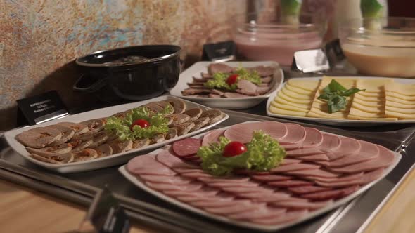 Sausage and Cheese Slicing Are on Plates at Breakfast Buffet, Morning in Hotel