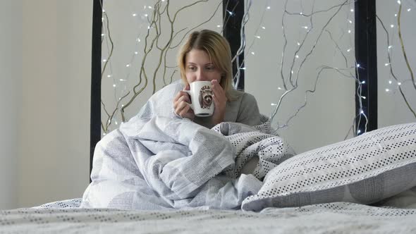 Girl drinking coffee in bed