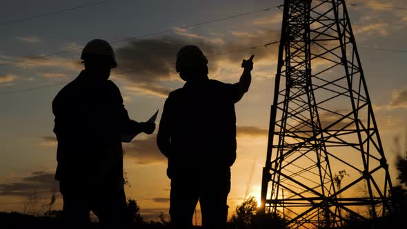 Silhouette of Engineers Looks at the Construction of High-voltage Power. Teams Engineer Looking