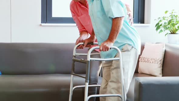 A senior woman helping a senior man standing