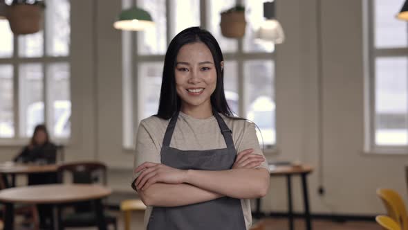 Adorable Cafe Owner in Apron Standing with Crossed Arms