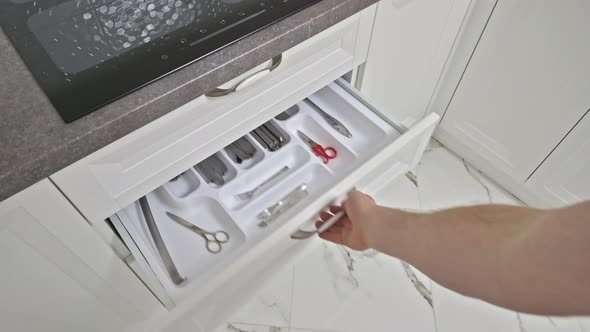 Male Hand Picks Some Table Kives From Kitchen Drawer