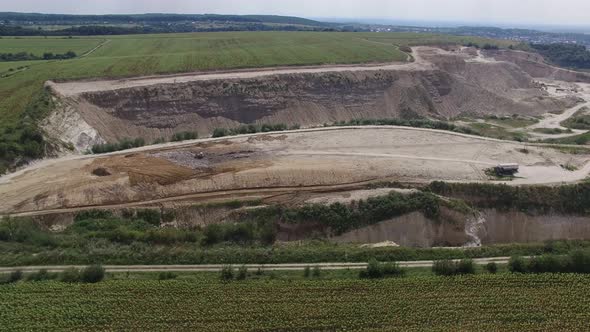 Aerial shot of landfill with working excavator moving garbage. 4K