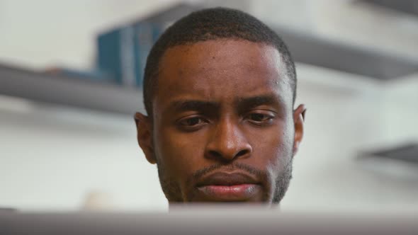 Young african freelancer man working on computer at home