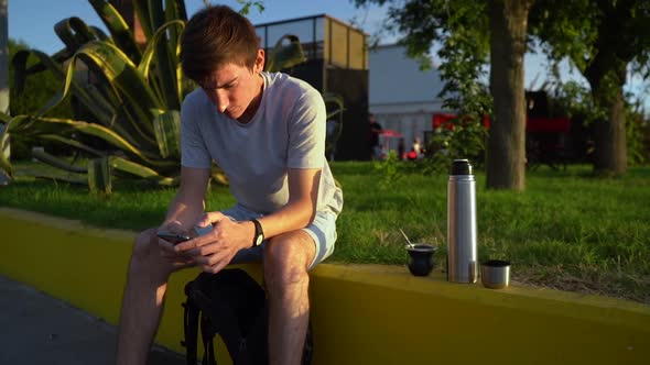 Lone Guy Using Smartphone After Drinking Hot Coffee At Sunny Morning Near Port Of Puerto Ingeniero W