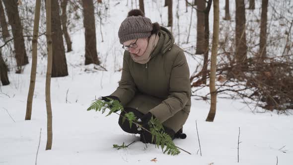 Woman in Glasses Holds in Hands with Smile Examines Green Leaves of Fern