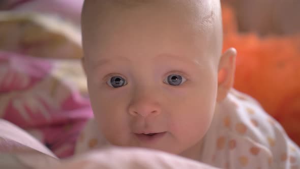 Portrait of Baby Girl with Big Blue Smiling Eyes