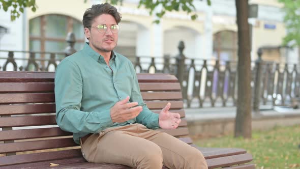 Man Feeling Angry While Sitting on Bench Outdoor