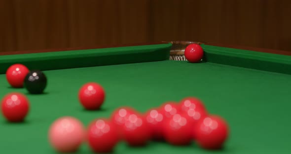 Striking snooker ball on table