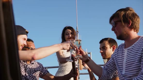 A Company of Young Friends Enjoys Celebrating a Birthday on Yacht in the Daytime