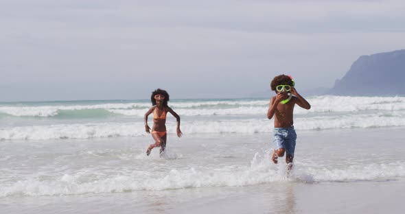 African american children wearing scuba goggles playing at the beach
