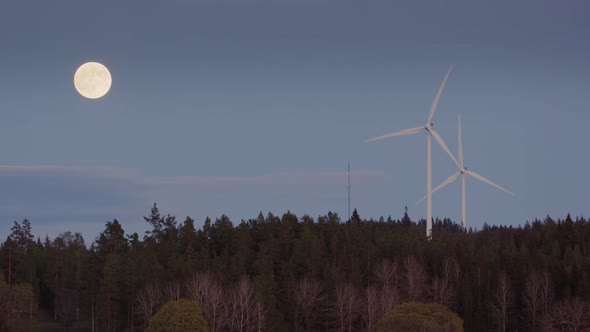 FULL MOON, TWILIGHT, ZOOM IN - Wind turbines spinning next to a full moon