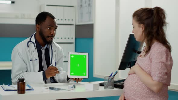 Male Doctor Showing Tablet with Greenscreen on Display