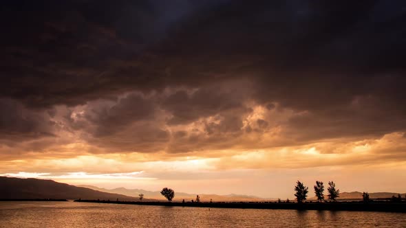 Time lapse of dark storm clouds during colorful sunset