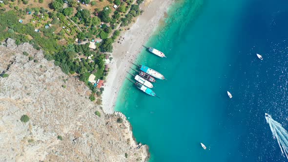 aerial top down view of the turquoise blue water at Butterfly Valley with large tourist boats anchor