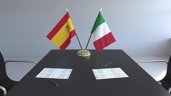 Flags of Spain and Italy on the Table alt