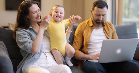 Man Works From Home with His Wife and Little Son