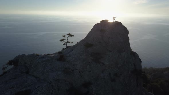 Flight Over of Young Woman Dancing on the Top of a Mountain Above the Sea. Lady on the Summit in