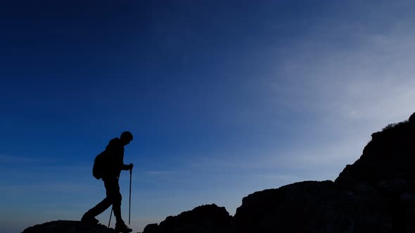 the Silhouette of a Man in the Mountains Against a Clear Sky