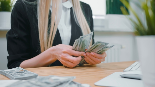 Business Woman Counting Cash in Hands. Crop View of Female in Elegant Suit Sitting at Wooden Desk