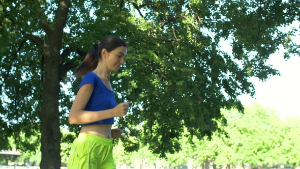 Beautiful Fitness Woman Jogging in Summer Park