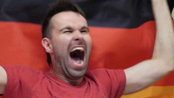 German Fan Celebrating While Holding the Flag of Germany