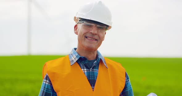 Male Engineer Working While Holding Blueprint