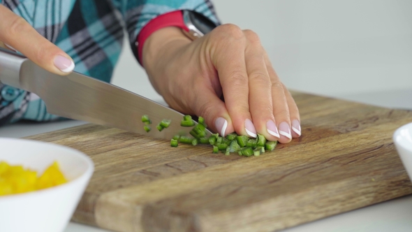Woman's Hands Slicing Sweet Bell Pepper on a Wooden Cutting Healthy Food Concept