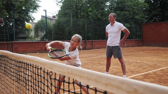 Coacher Teaching Young Girl To Playing Tennis