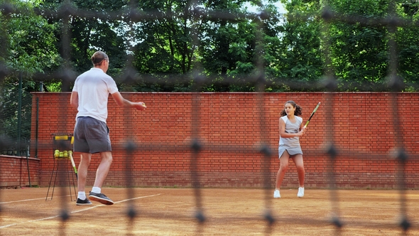 Coacher Teaching Young Girl To Playing Tennis.