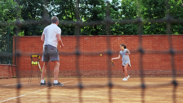 Coacher Teaching Young Girl To Playing Tennis