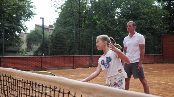 Coacher Teaching Young Girl To Playing Tennis