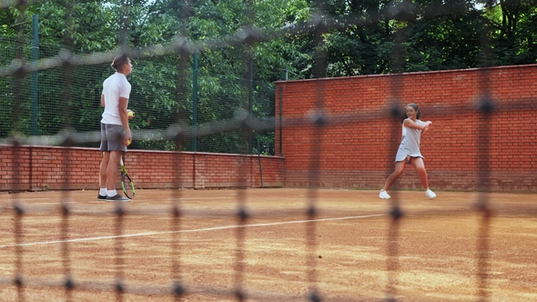 Coacher Teaching Young Girl To Playing Tennis