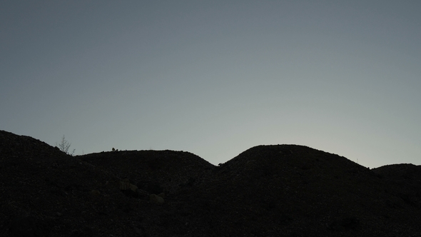 Silhouette of Businessman Jumping Over Obstacles at Sunset