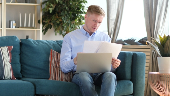 Middle Aged Man Working on Documents and Laptop