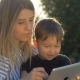 Child with Tablet and Mother on a Bench in the Park - VideoHive Item for Sale