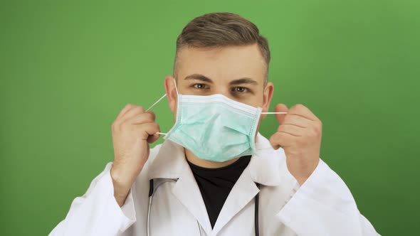 Caucasian Man Posing as Medical Doctor Taking Off Protective Face Mask and Smiling