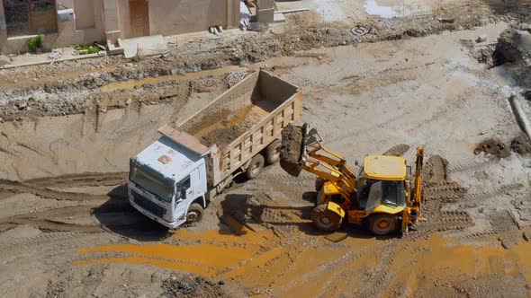 Excavator loads pit onto truck (hydraulic) of heavy construction