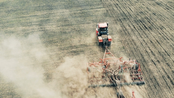 Aerial Drone Shot of a Farmer in Tractor Seeding